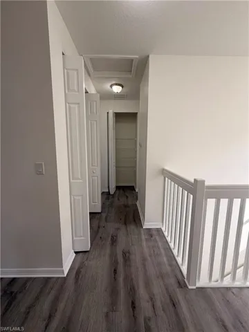 Wood-finish flooring throughout, white interior doors, and a white baluster railing