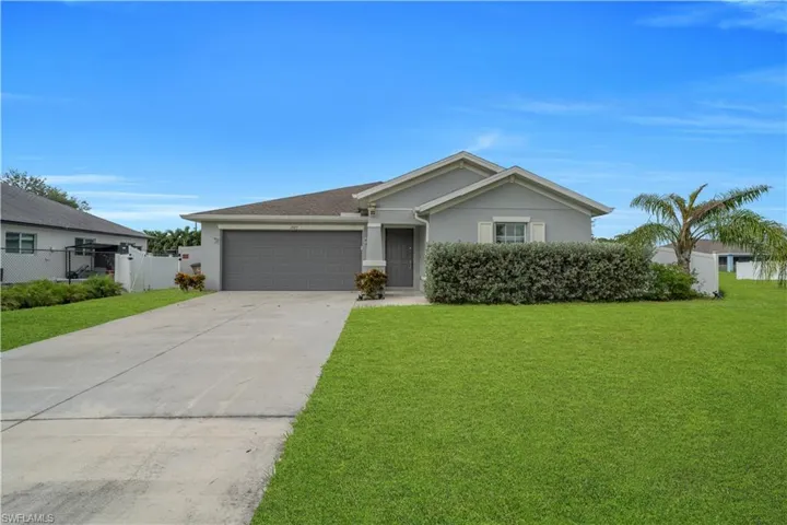 Single-story residence featuring a gray exterior, attached two-car garage, and a concrete driveway