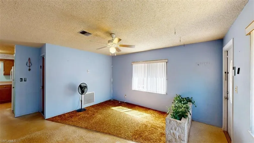 living room with a textured ceiling and a ceiling fan