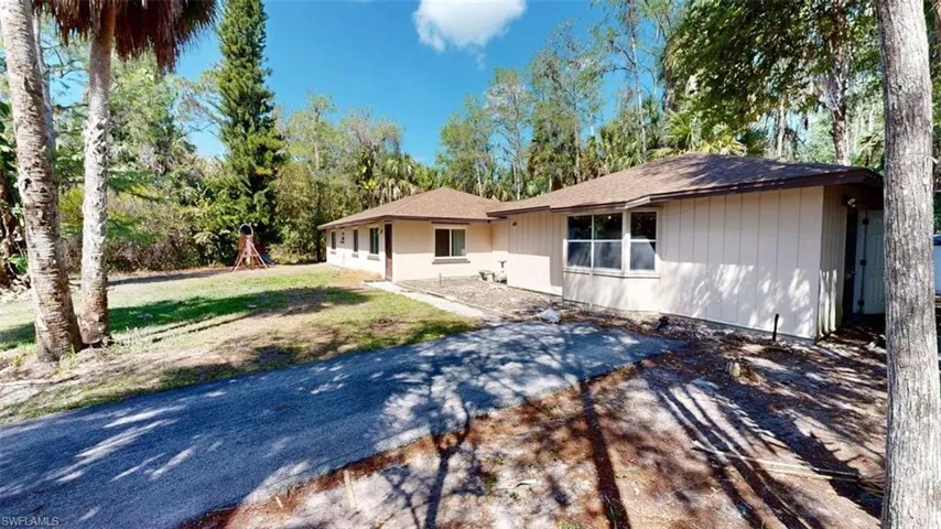 Ranch-style home featuring a playground, a shingled roof, and a front yard