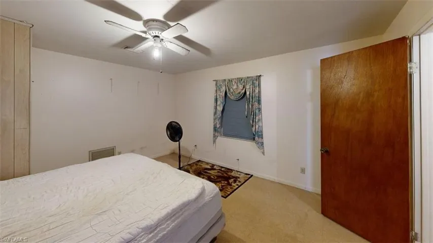 Bedroom featuring a ceiling fan and light colored carpet