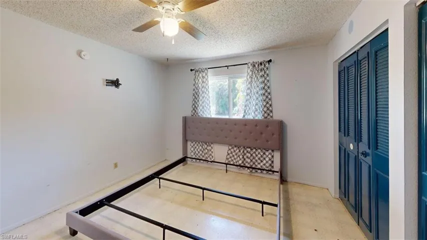 Bedroom featuring a ceiling fan, a closet, and a textured ceiling