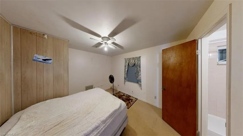 Bedroom with light carpet and a ceiling fan