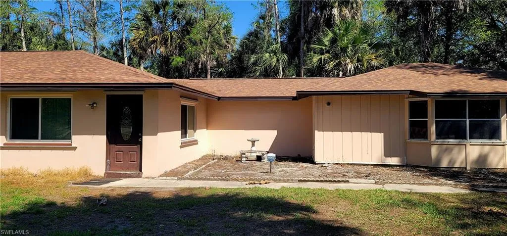 View of front of house featuring roof with shingles and a front lawn
