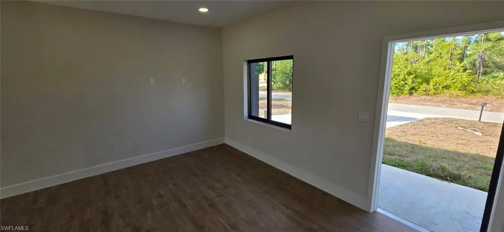 Empty room featuring dark wood-style flooring and recessed lighting