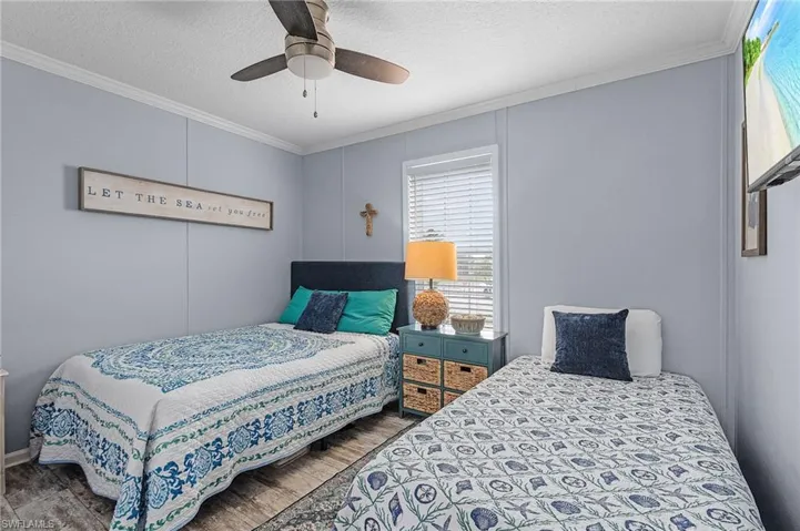Bedroom featuring a textured ceiling, ceiling fan, dark hardwood / wood-style floors, and ornamental molding