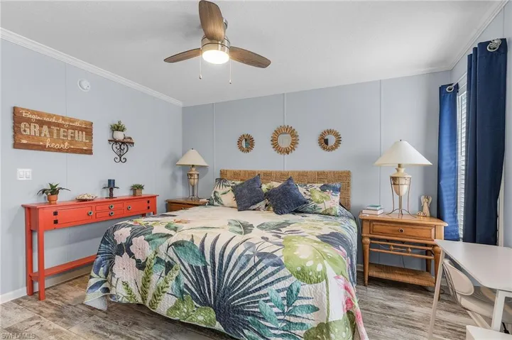 Bedroom featuring wood-type flooring, ceiling fan, and ornamental molding