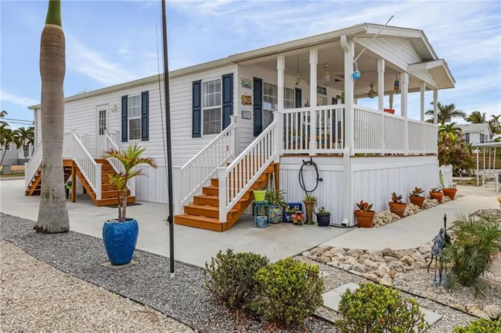 View of front of home with ceiling fan and a porch