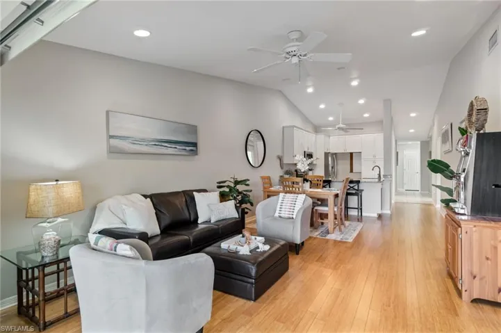 Living area with recessed lighting, light wood-style floors, lofted ceiling, and ceiling fan