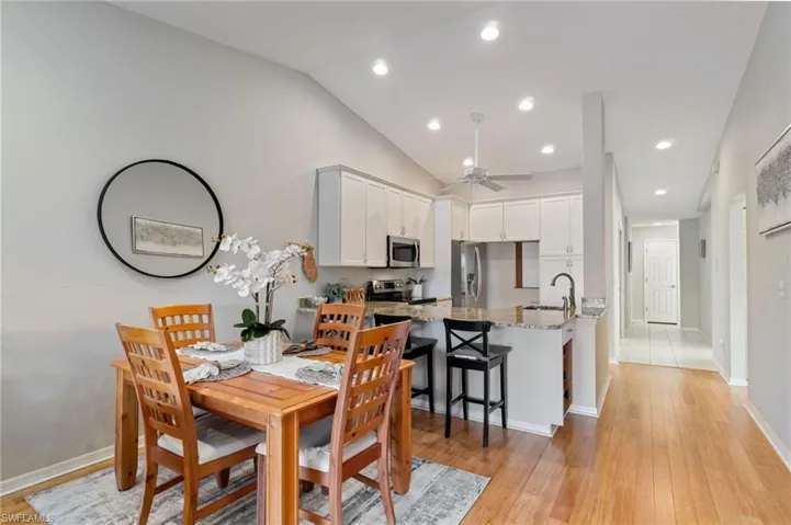 Dining room featuring light wood-style flooring, recessed lighting, vaulted ceiling, and ceiling fan
