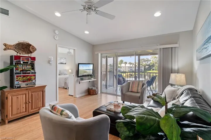 Living room with recessed lighting, lofted ceiling, bamboo floors, and a ceiling fan