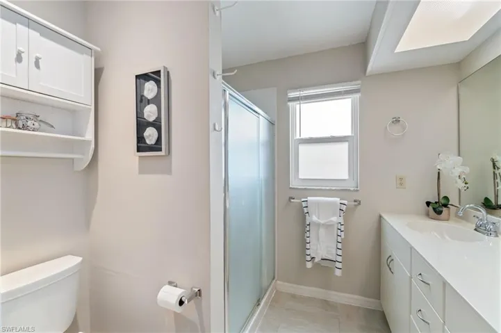 Full bathroom with vanity, a stall shower, and light tile patterned floors