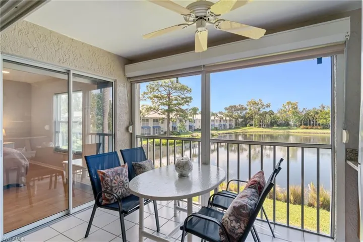 Lanai with tile patterned floors, a textured wall, and a water view