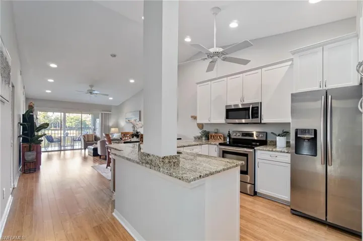 Kitchen with stainless steel appliances, a ceiling fan, recessed lighting, a peninsula, and vaulted ceiling