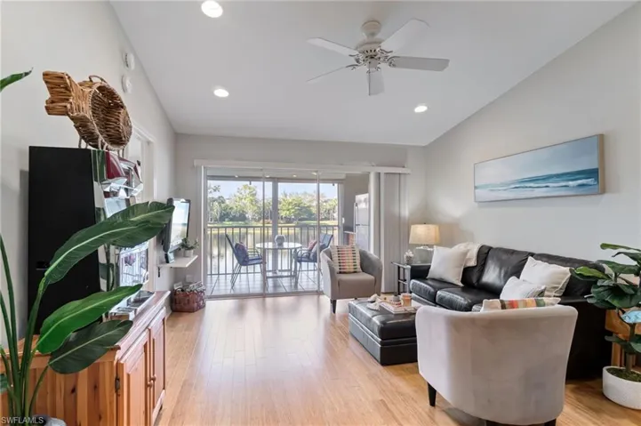 Living area with light bamboo floors, recessed lighting, a ceiling fan, and lofted ceiling