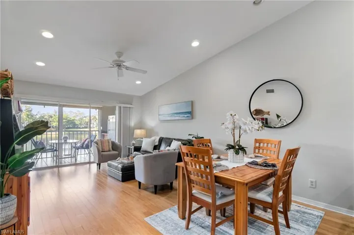 Dining room featuring bamboo flooring, lofted ceiling, recessed lighting, and a ceiling fan