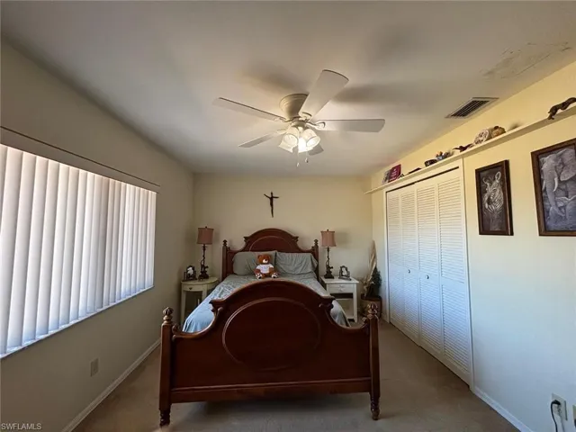 Bedroom with ceiling fan, carpet floors, and a closet