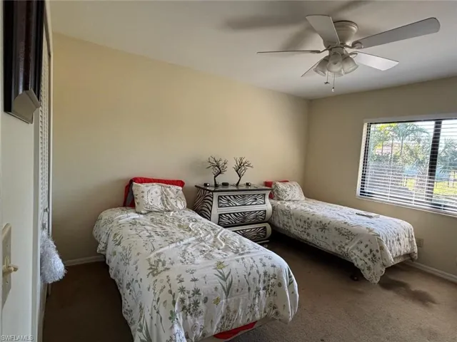Carpeted bedroom featuring a ceiling fan and baseboards