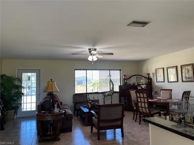 Living area with ceiling fan and light tile patterned flooring