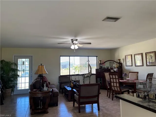 Living room with plenty of natural light, a ceiling fan, and light tile patterned flooring