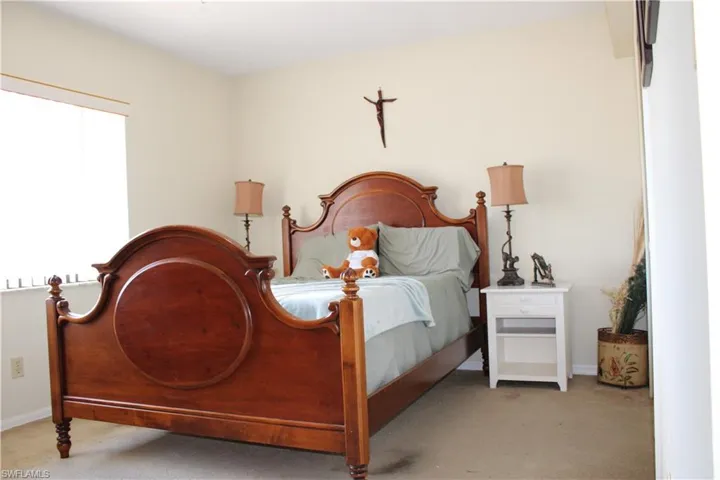Bedroom featuring light colored carpet and baseboards