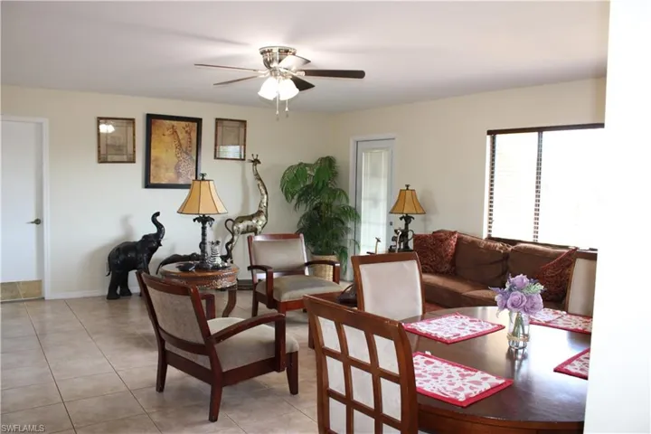 Living room featuring light tile patterned floors and ceiling fan