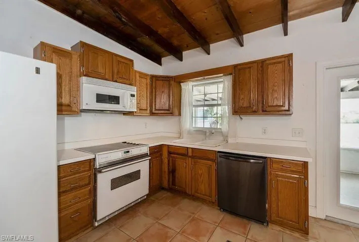 Kitchen with beam ceiling, wooden ceiling, white appliances, and light tile floors