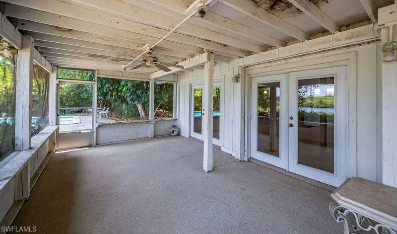 Unfurnished sunroom with ceiling fan and french doors