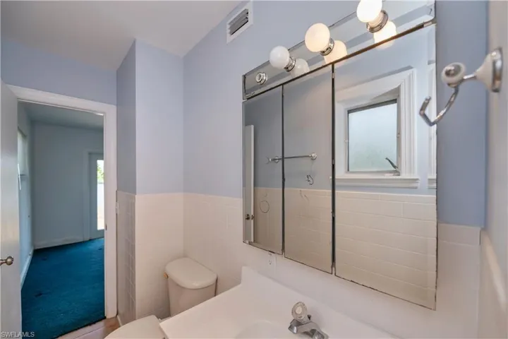 Bathroom with tile walls, sink, and toilet