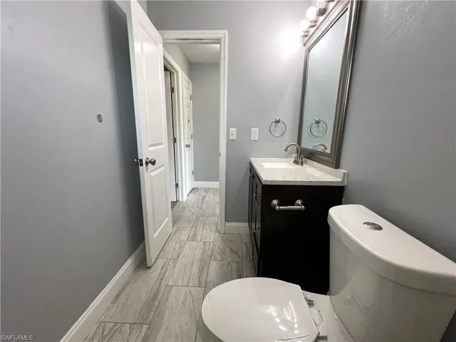 Bathroom featuring vanity with extensive cabinet space and toilet