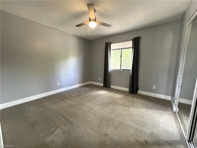 Empty room featuring carpet and ceiling fan