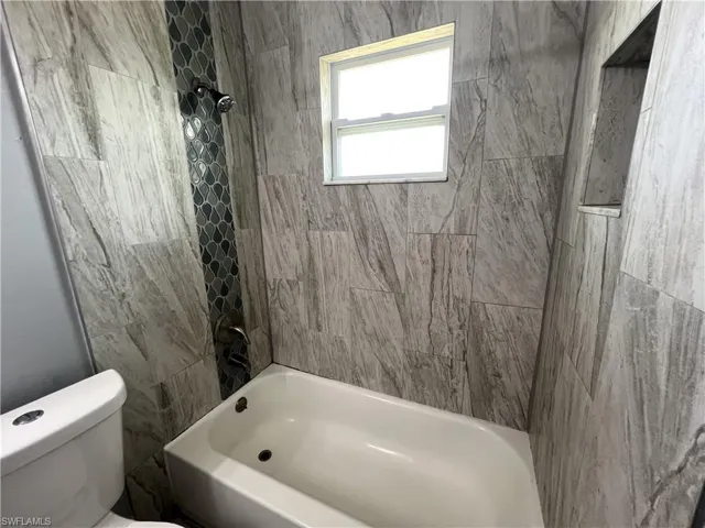 Bathroom featuring toilet and tiled shower / bath combo