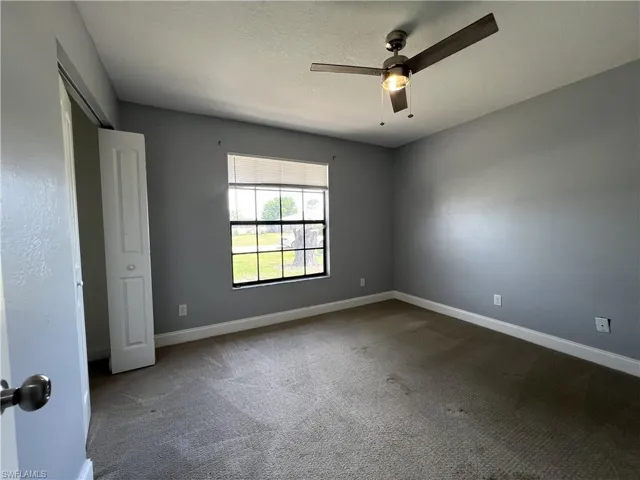 Spare room featuring carpet and ceiling fan