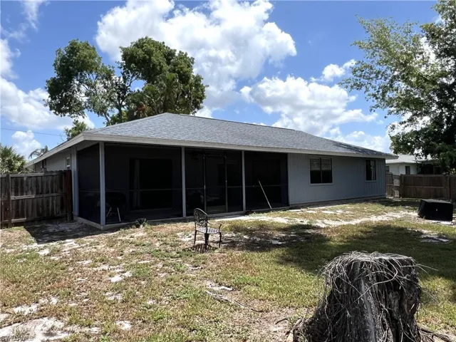 Rear view of property with a yard
