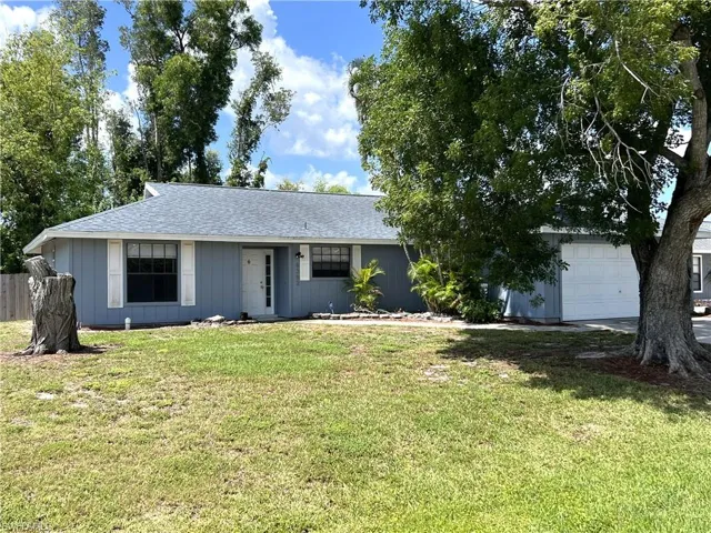 Ranch-style house with a front lawn and a garage