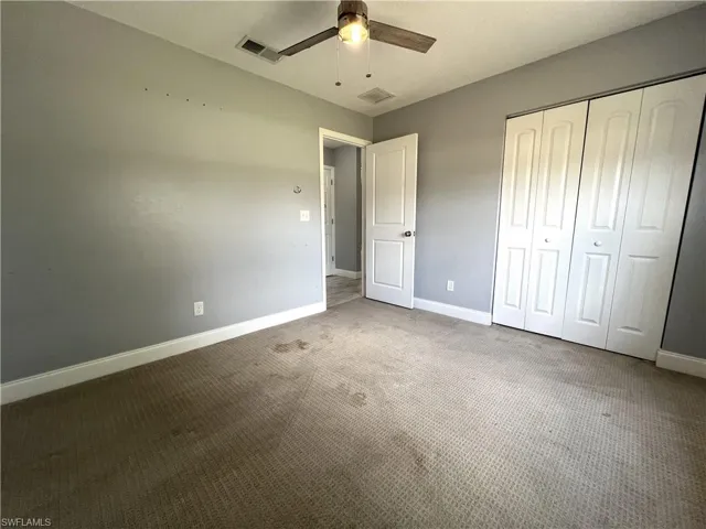 Unfurnished bedroom with carpet flooring, a closet, and ceiling fan