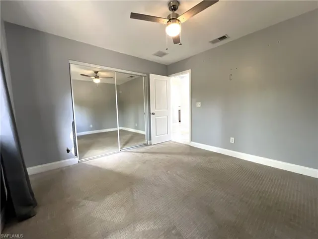 Unfurnished bedroom featuring carpet, a closet, and ceiling fan