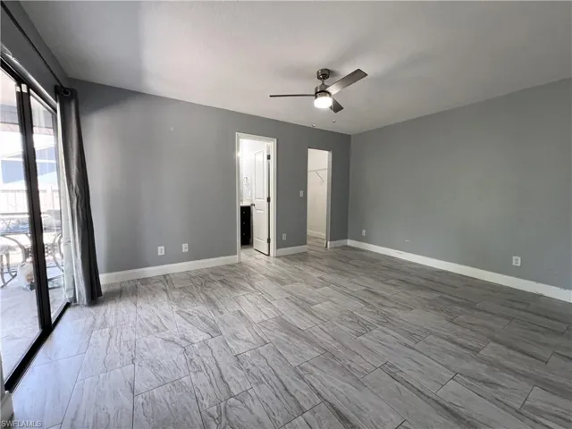 Tiled spare room featuring ceiling fan