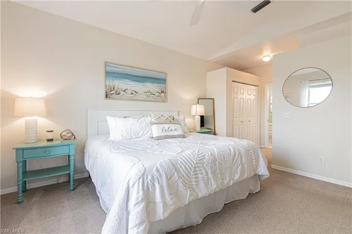 Bedroom with carpet, a closet, baseboards, vaulted ceiling, and a ceiling fan