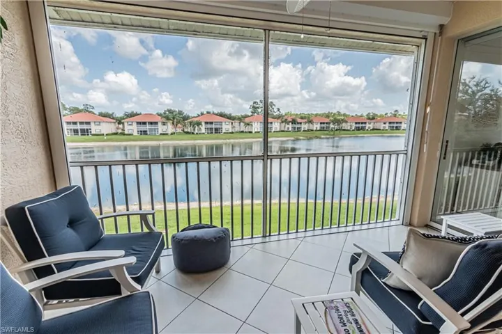 Sunroom / solarium featuring a water view, plenty of natural light, and a residential view