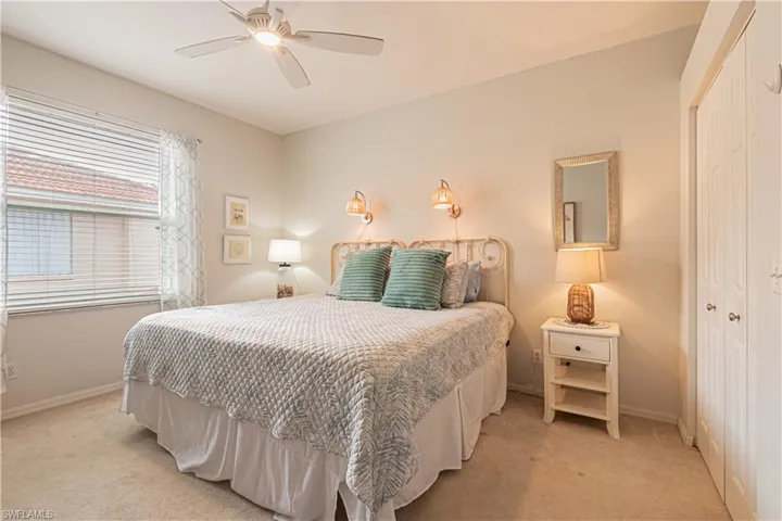 Bedroom with a closet, light carpet, and baseboards