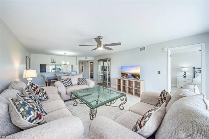 Living room featuring a ceiling fan and a chandelier
