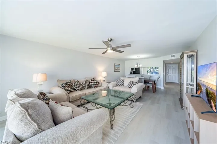 Living area featuring a chandelier, light wood-style flooring, and ceiling fan