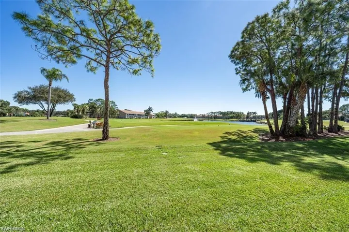 View of property's community featuring a lawn, a water view, and view of golf course