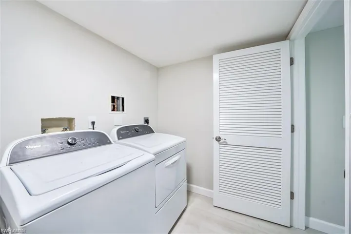 Laundry room featuring independent washer and dryer and light wood-type flooring