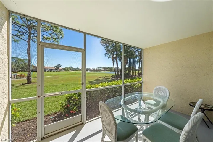 Sunroom featuring outdoor dining area and view of golf course