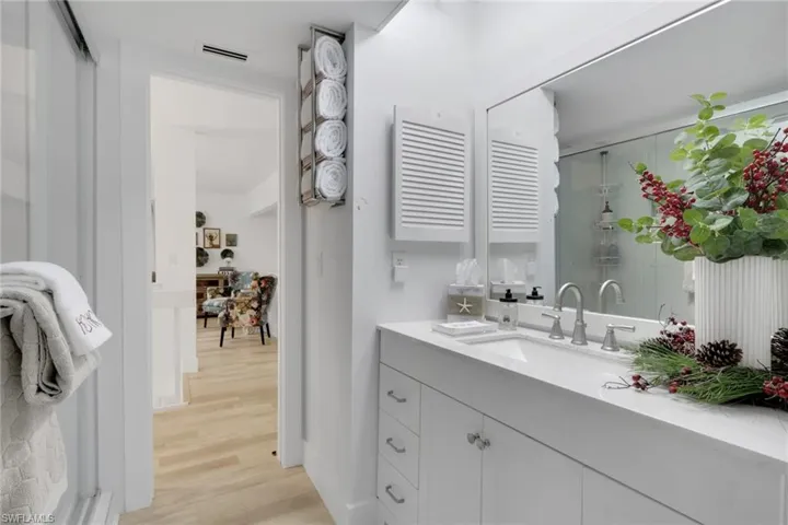 Bathroom with vanity, light wood finished floors, and a shower stall