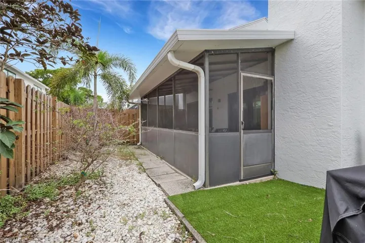 Fenced backyard featuring a screened lanai