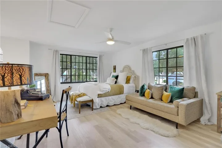 Loft featuring multiple windows, wood finished floors, and ceiling fan