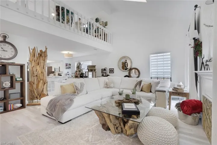 Living room with wood finished floors, a high ceiling, and a fireplace